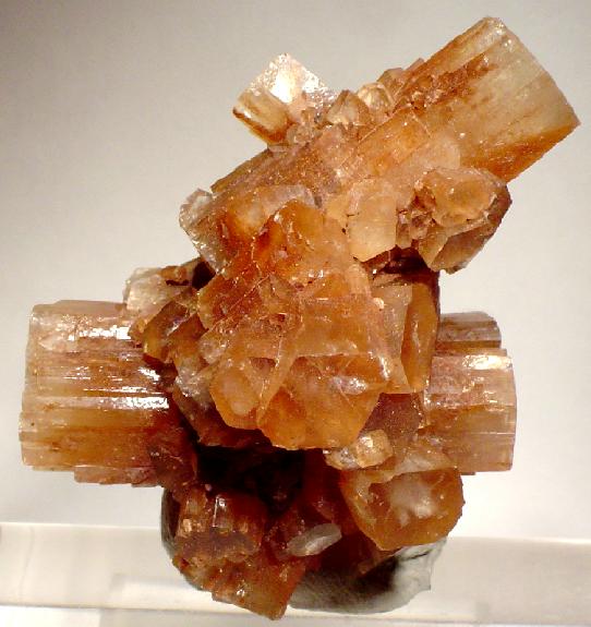 Honey-brown aragonite prisms projecting in several directions from a cluster